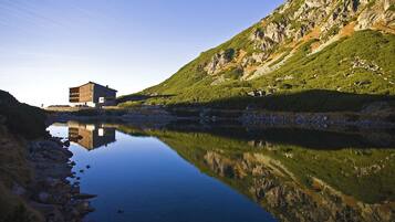 A building with a modern design, situated by a calm lake with clear reflections.