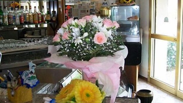 A flower arrangement on a counter with a window in the background. - Bed & Breakfast Locanda La Rotonda (Montale)
