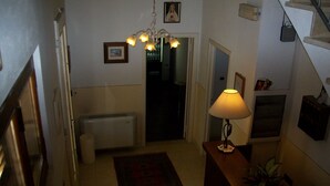 A staircase leading to a landing with a lamp, a radiator, and a framed picture on the wall. - Bed & Breakfast Locanda La Rotonda (Montale)