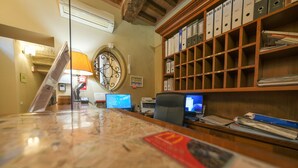 Een receptiebalie met een kaart, computers en een archiefkast.