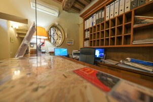 Un mostrador de recepción con un mapa, computadoras y un archivador.