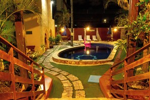 A pool area with a wooden deck, lounge chairs, and a small pool. - Hotel Palmanova (Maceió)