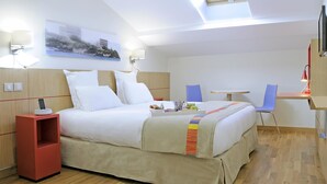 A hotel room with a bed, a desk, a chair, a TV, and a painting on the wall. - Best Western Hotel du Mucem (Marseille)