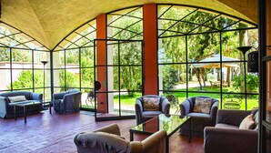 A covered patio area with seating and large windows. - Agrirelais Baglio di Pianetto (Santa Cristina Gela)