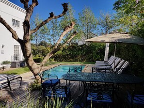 室外游泳池，池畔遮阳伞，日光浴躺椅