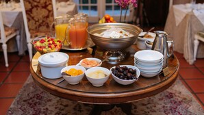 A breakfast buffet with various food items and beverages on a wooden table. - Maison Chablis (Franschhoek)