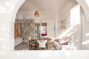 A cozy dining area with a table, chairs, and a hanging light fixture.