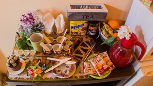 Un bufé de desayuno con diversos alimentos, como bollería, frutas y bebidas.