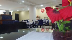 A hotel lobby with a reception desk, check-in counters, and a dining area with tables and chairs. - Flat Residencial La Perla (Fortaleza)