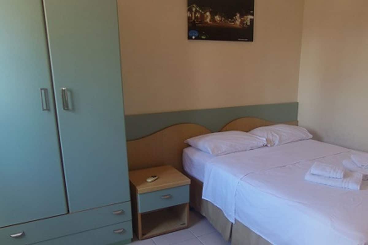 Un dormitorio con cama, mesita de noche y armario.