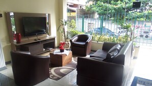 A living room with a television, two sofas, a coffee table, and a potted plant. - Flat Residencial La Perla (Fortaleza)