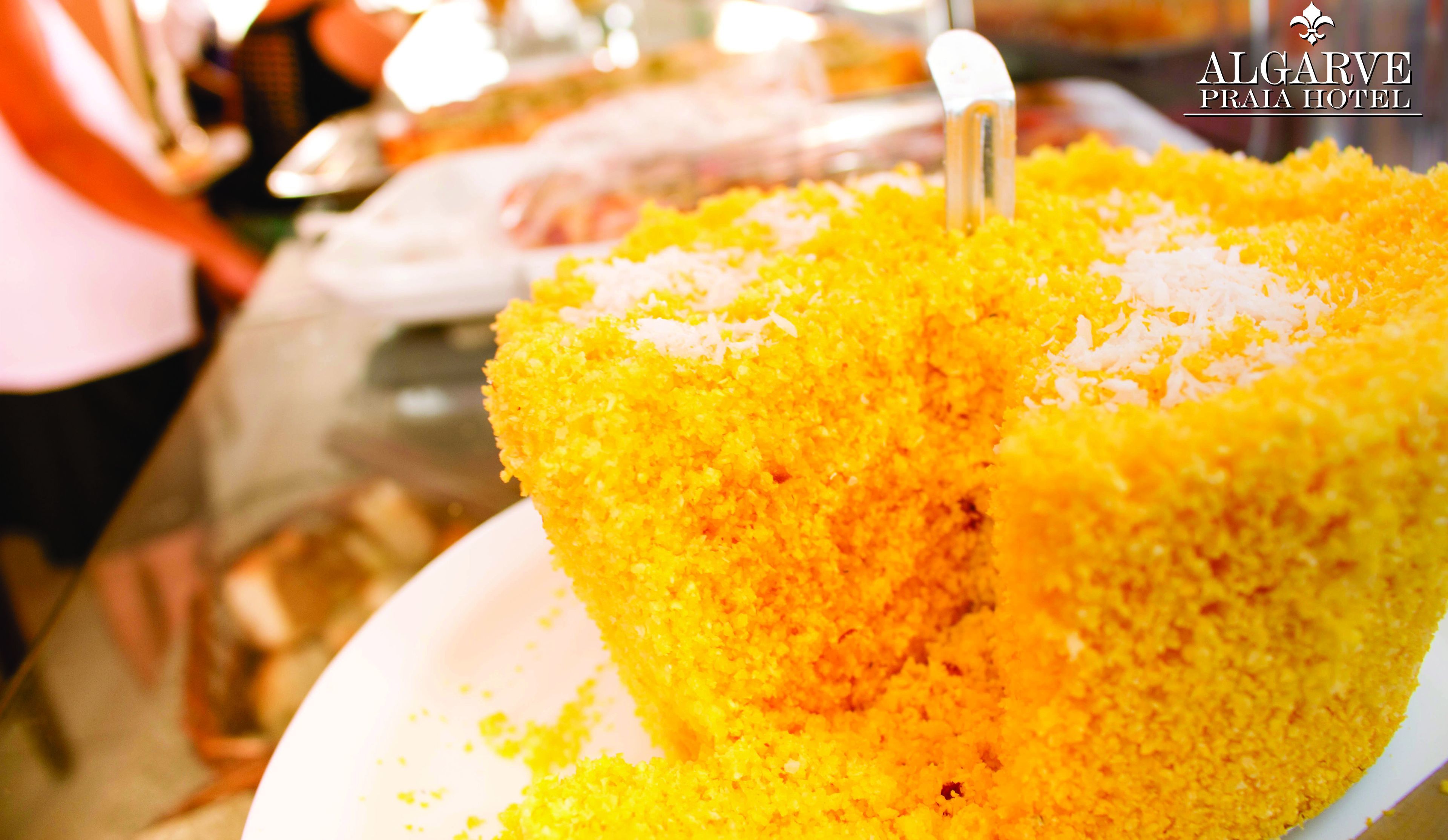 Une vue rapprochée d’un gâteau jaune, avec une fourchette posée sur une assiette blanche.