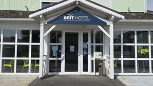 A BRIT HOTEL with a prominent entrance, large windows, and a green exterior. - Brit Hotel Essentiel Poitiers – Gare du Futuroscope (Jaunay-Marigny)