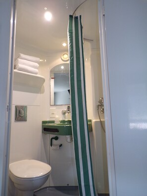 Un baño pequeño y funcional con inodoro, lavabo y toallero.