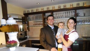 A family of three at a bar with a wine glass on the table. - Hotel-Gasthof-Fellner (Furth im Wald)