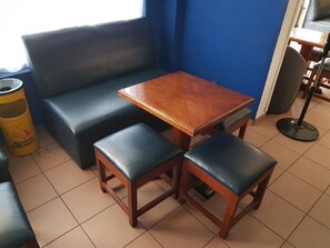 Una zona de estar con un sofá, una mesa de madera y dos sillas a juego.