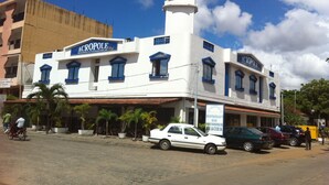 Um edifício de dois andares com uma placa que diz "ACROPOLÉ Restaurant Bar Patisserie".