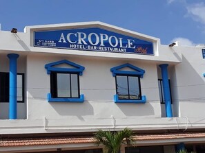 Un edificio con un cartel que dice "ACROPOL HOTEL BAR-RESTAURANT".