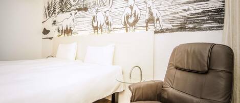 Ein Hotelzimmer mit einem Bett, einem braunen Ledersessel und einem Wandgemälde, das eine ländliche Szene mit Schafen und einem Schiff zeigt.