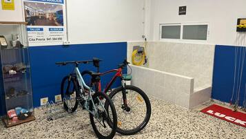 Un atelier de réparation de vélos avec deux vélos, un comptoir d’accueil et un tapis rouge sur lequel est écrit le mot « CHANCE ».