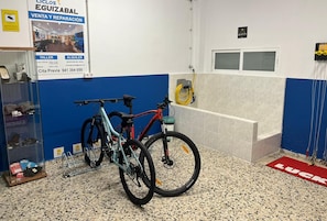 A bicycle repair shop with two bicycles, a reception desk, and a red carpet with the word "LUCK". - ibis Styles La Rioja Arnedo (Arnedo)