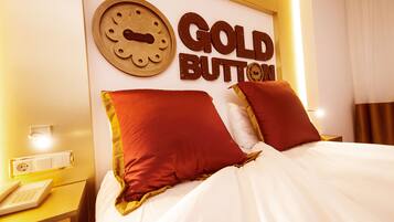 A hotel room with a bed, a wall clock, and a sign that reads "GOLD BUTTON".
