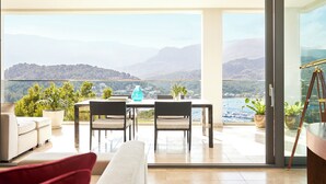 Een moderne kamer met een grote schuifglazen deur die leidt naar een balkon met een prachtig uitzicht op de bergen.
