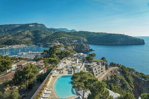 A coastal resort with a swimming pool, villas, and a marina.