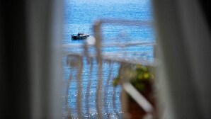 Vista de un barco en el mar a través de una ventana con barandilla de balcón.