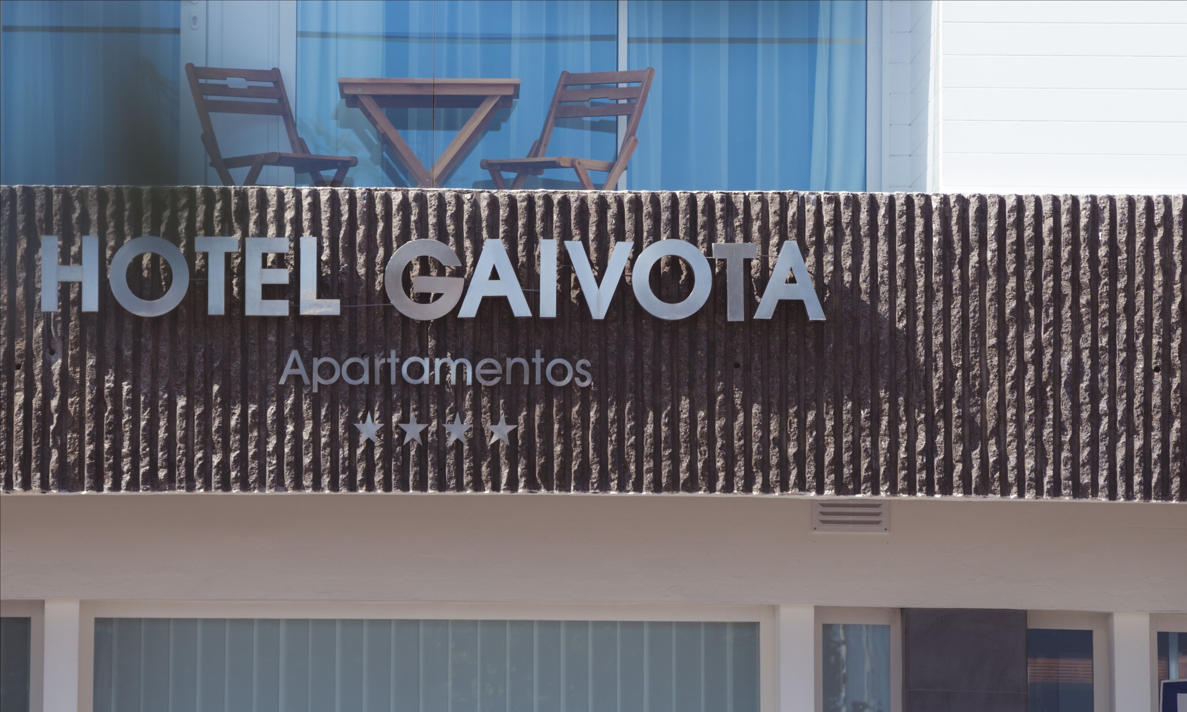 A sign for HOTEL CAIVOTA with the word 'Apartamentos' below it.