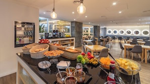 Un área de bufé con diferentes alimentos, cestas y un refrigerador.