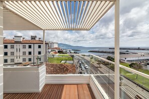Enjoy the stunning city view from this balcony overlooking the coastal landscape.