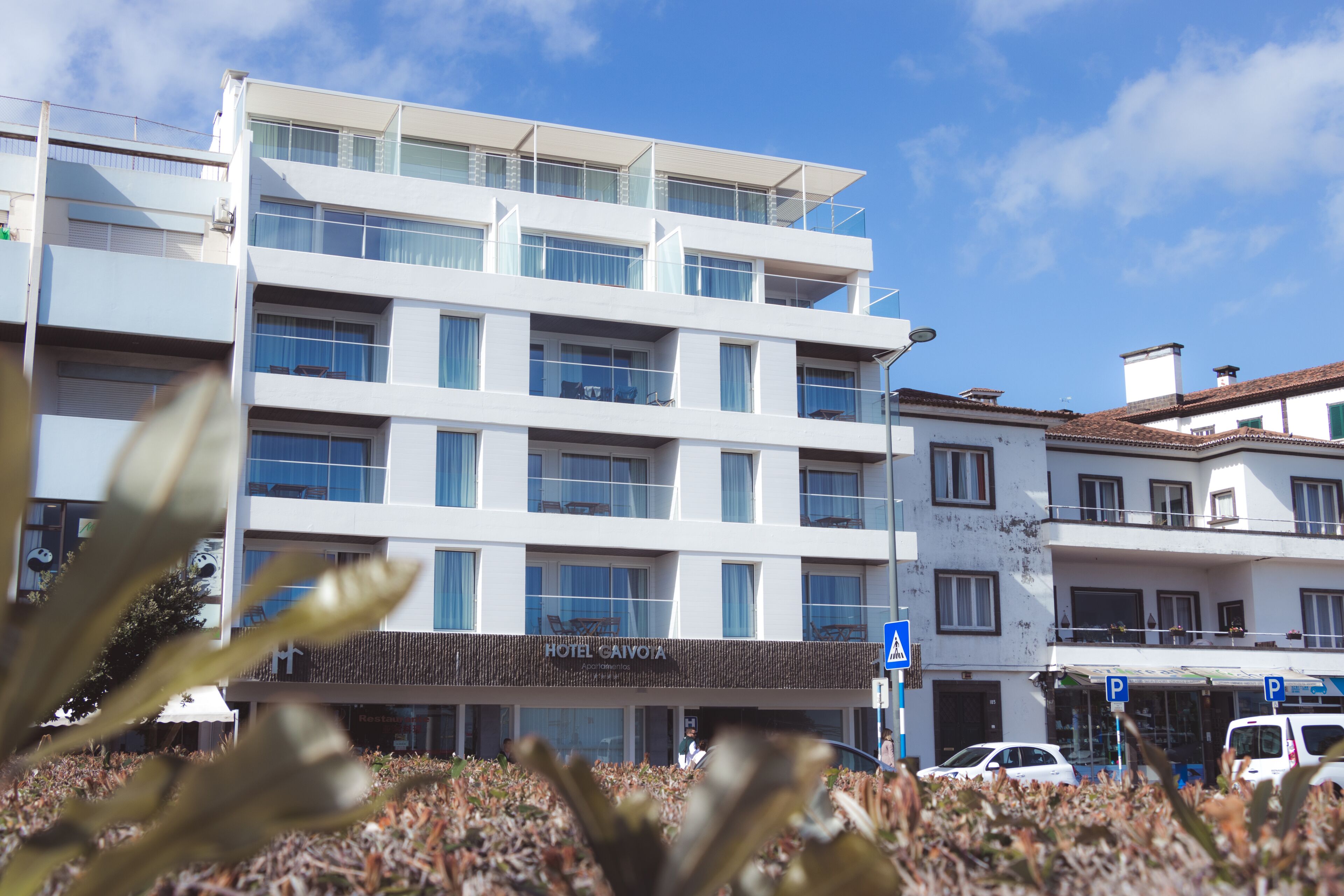 A multi-story hotel with a modern facade, balconies, and a visible restaurant named "Hotel Cavotta."