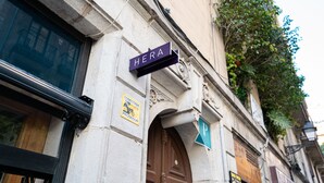 A building with a sign reading "HERA" and a "P" indicating parking. - Hostal Hera (Barcelona)