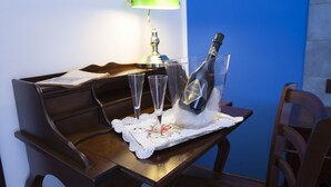 A wooden desk with a bottle of champagne, two glasses, and a green desk lamp. - Le Cinque Novelle (Agrigento)