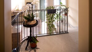 A spacious interior with a curved ceiling, a chandelier, potted plants, and a staircase. - Hotel Broletto Mantova - centro storico (Mantua)