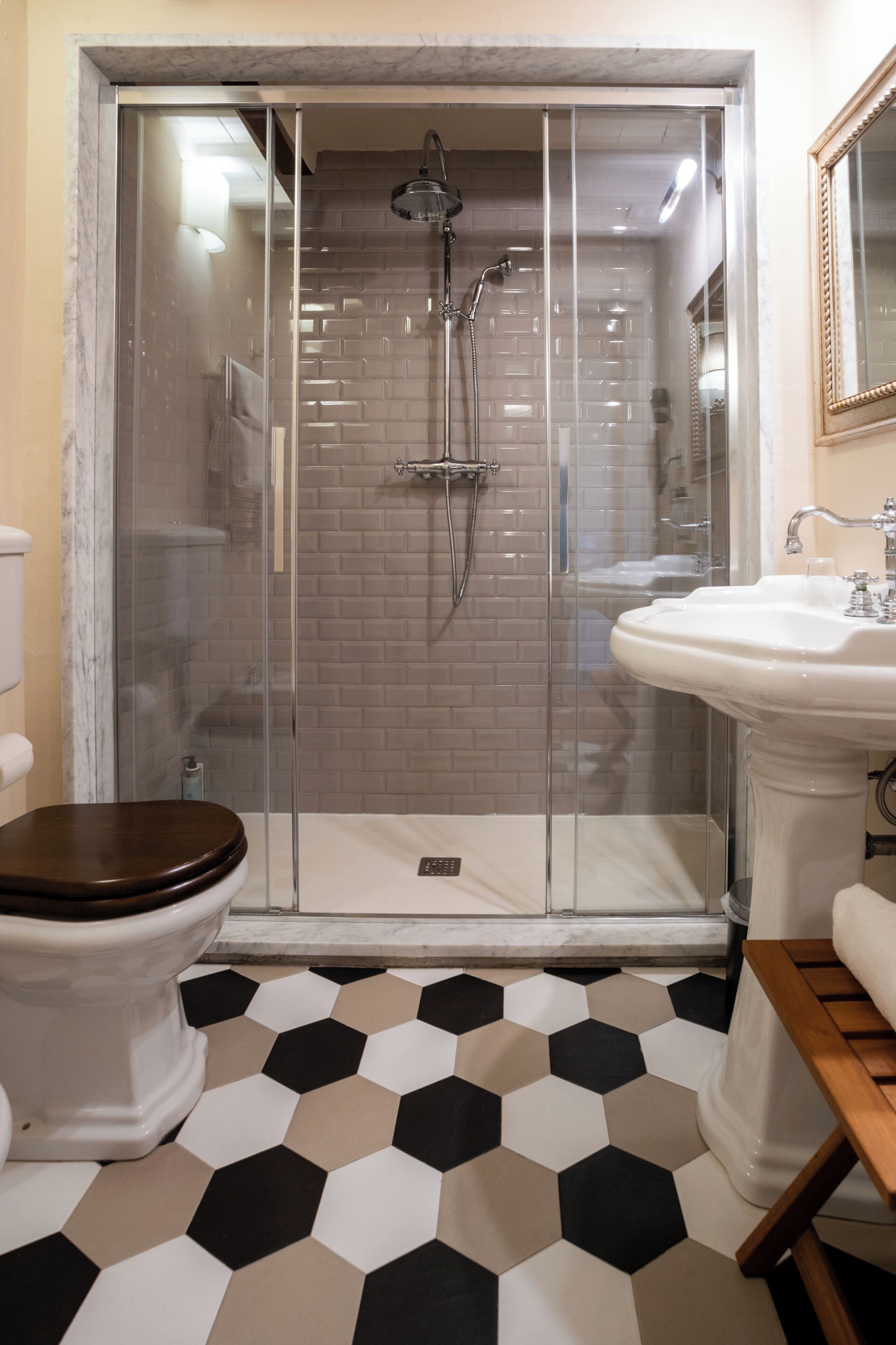 Ein Badezimmer mit Dusche, Toilette, Waschbecken und Fliesenboden.