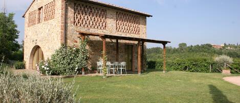 A stone building with a covered patio and outdoor seating.