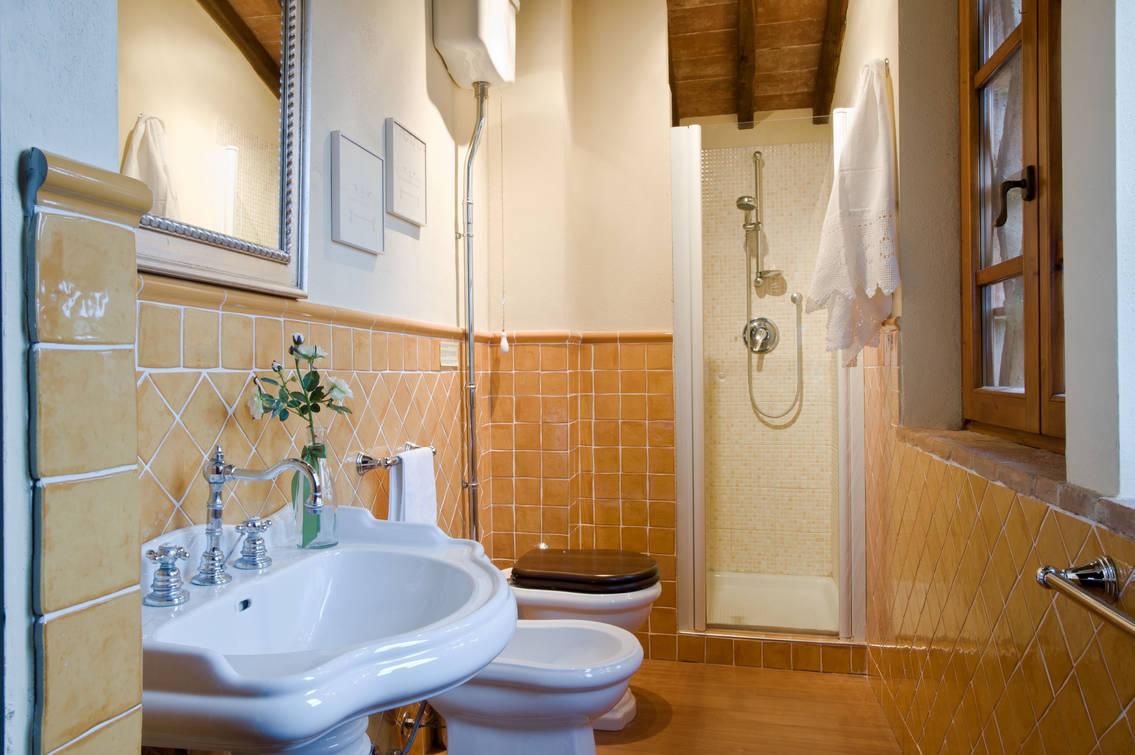 Un baño con lavamanos, dos inodoros, ducha y bañera.