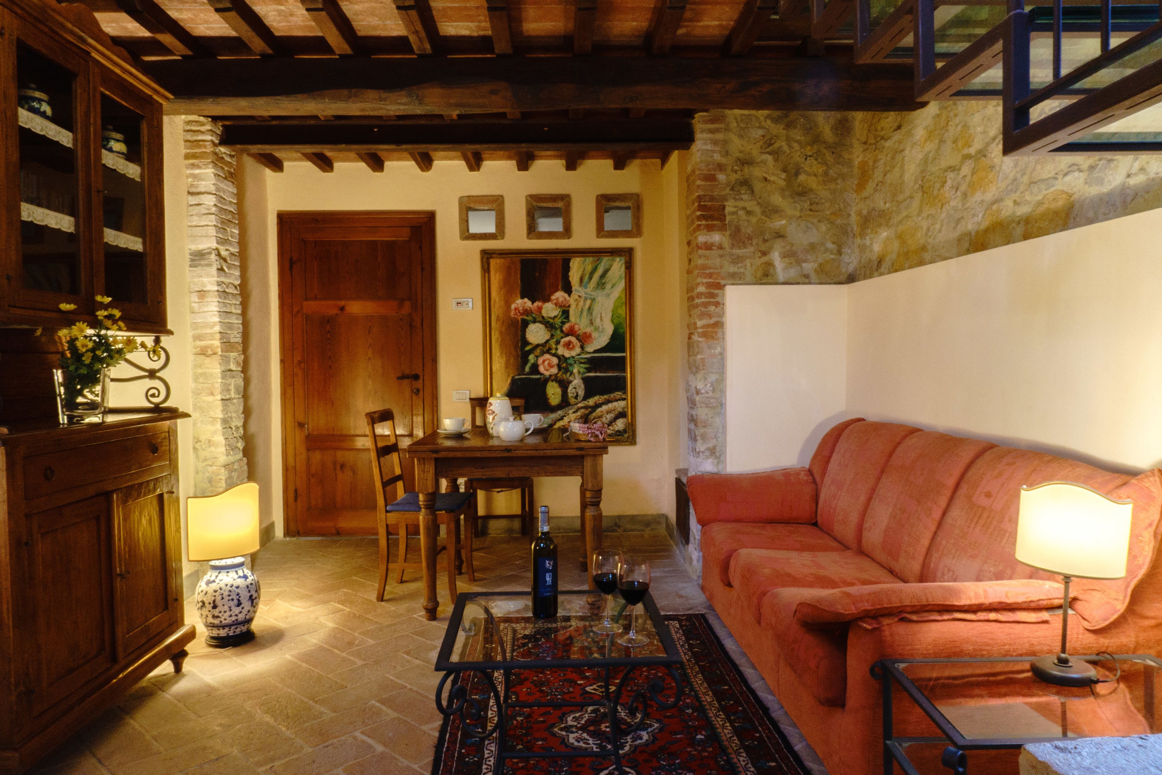 A cozy living room with a wooden sofa, a coffee table, and a dining area with a wooden table and chairs.