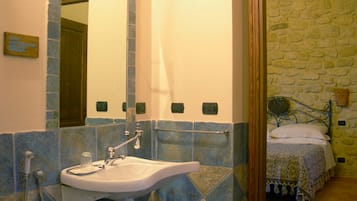 Un bagno con lavandino, specchio e doccia.