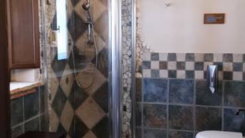 Un baño con cabina de ducha, inodoro y lavabo.