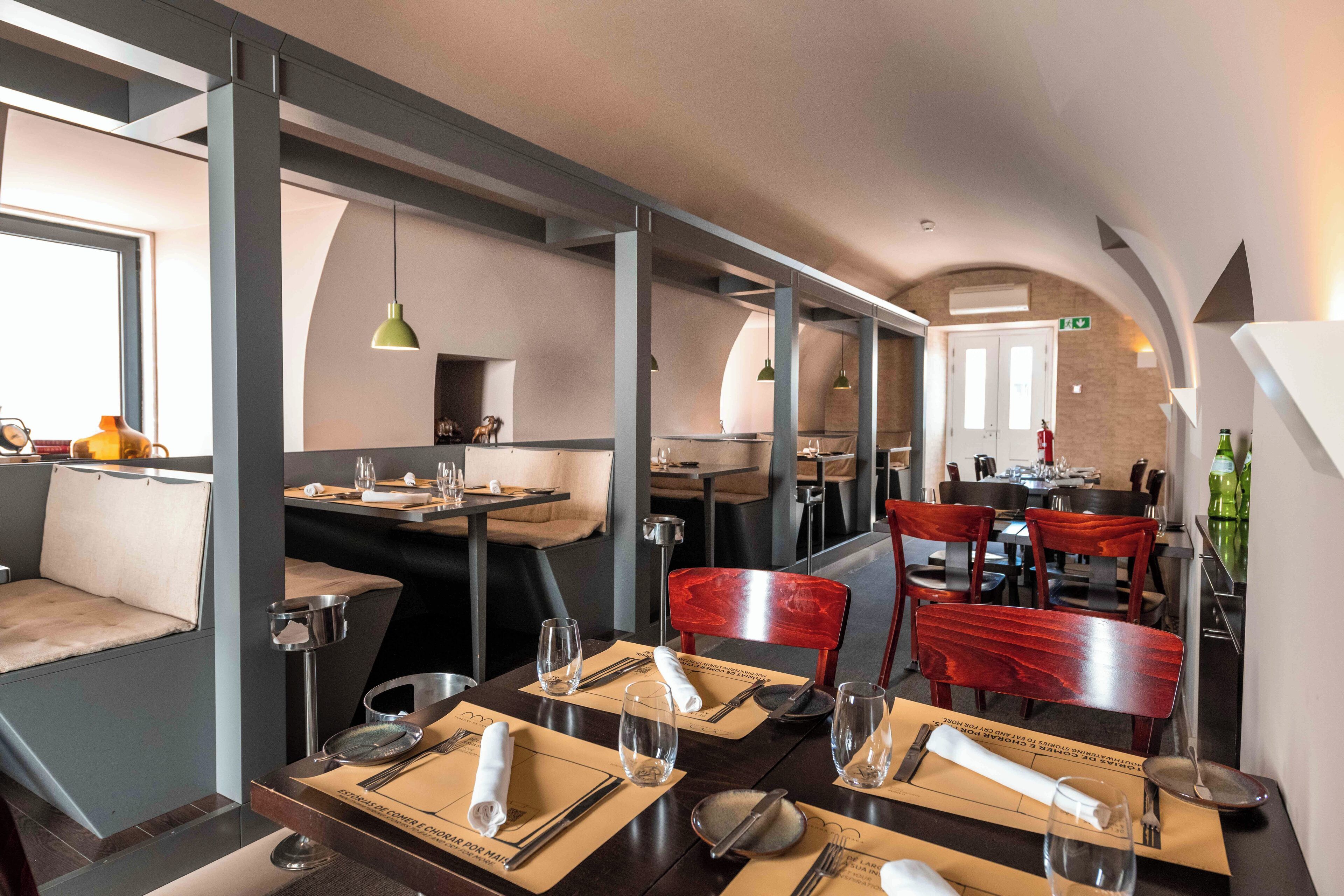 A restaurant with tables set for dining, chairs, and a counter area.