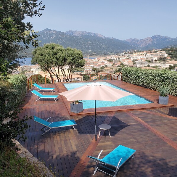 Alberca al aire libre y camastros