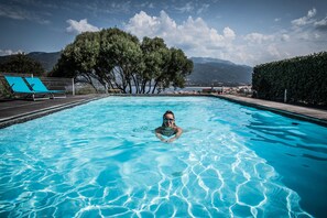 Alberca al aire libre y camastros