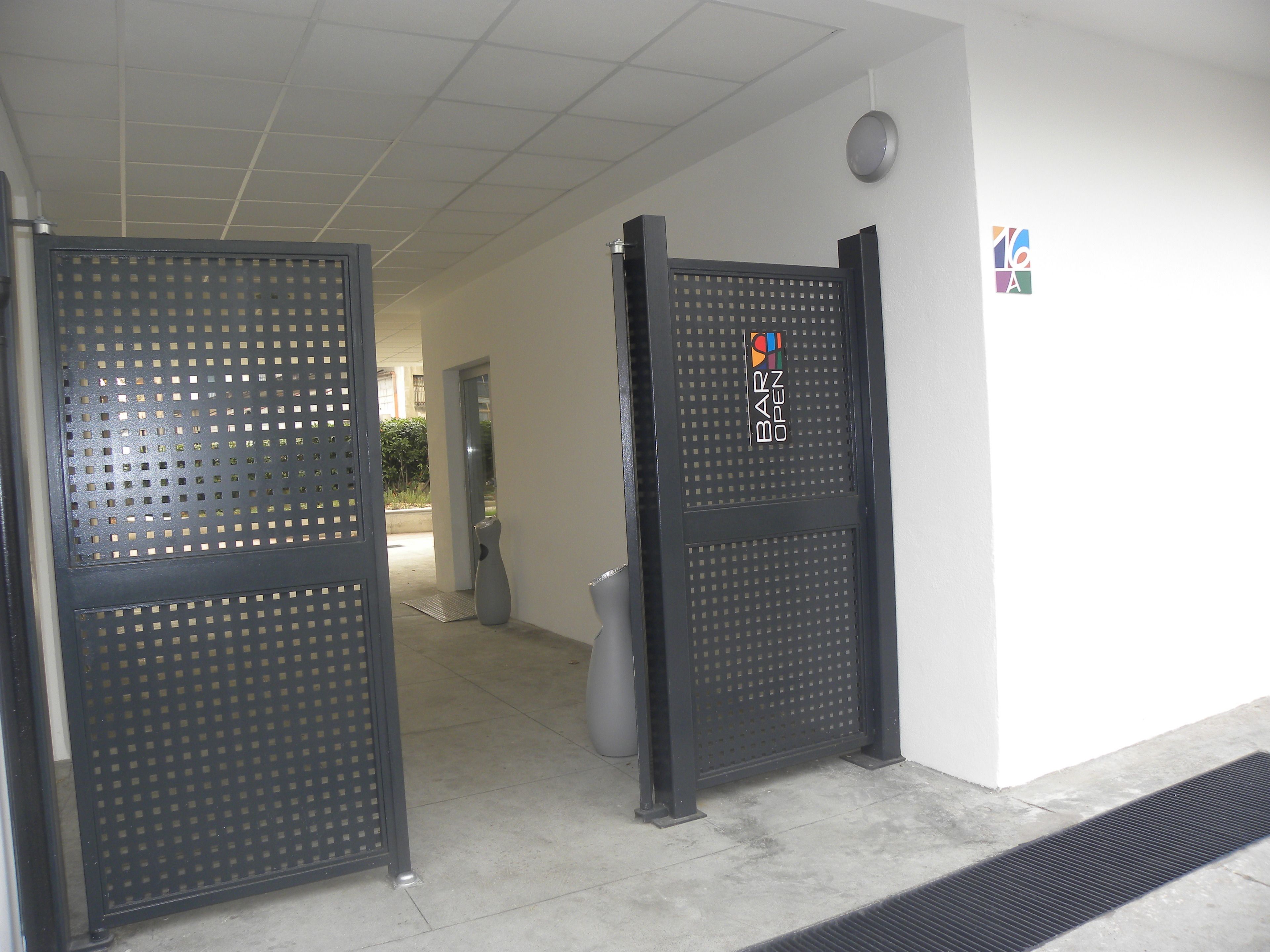 A doorway with a metal grille and a sign indicating "BAR OPEN".