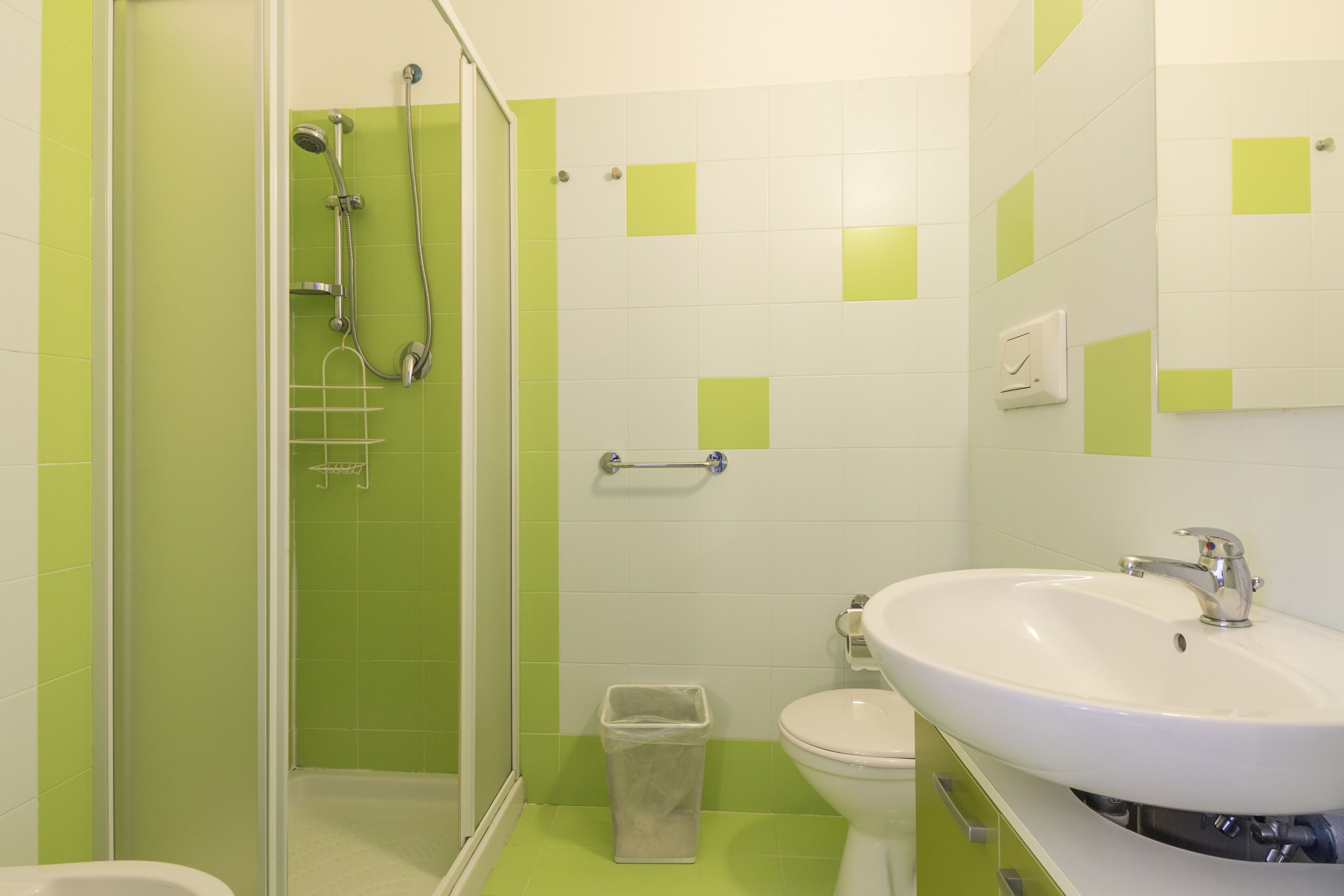 A bathroom with a shower, toilet, and sink.