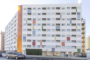 Un hotel a più piani dal design moderno, con una facciata uniforme e finestre e balconi rettangolari.