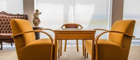 A room with a wooden table and two mustard-colored chairs.