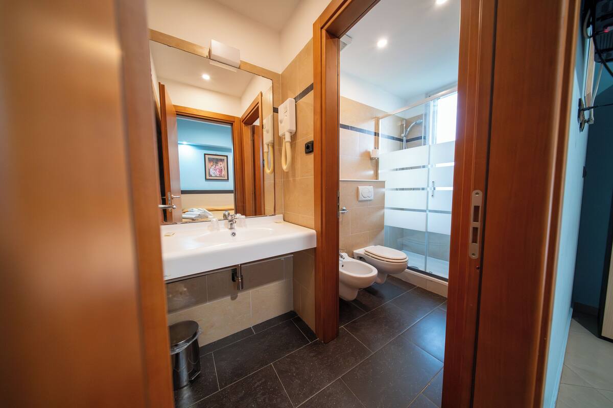 A modern bathroom with a large sink, toilet, and shower area.